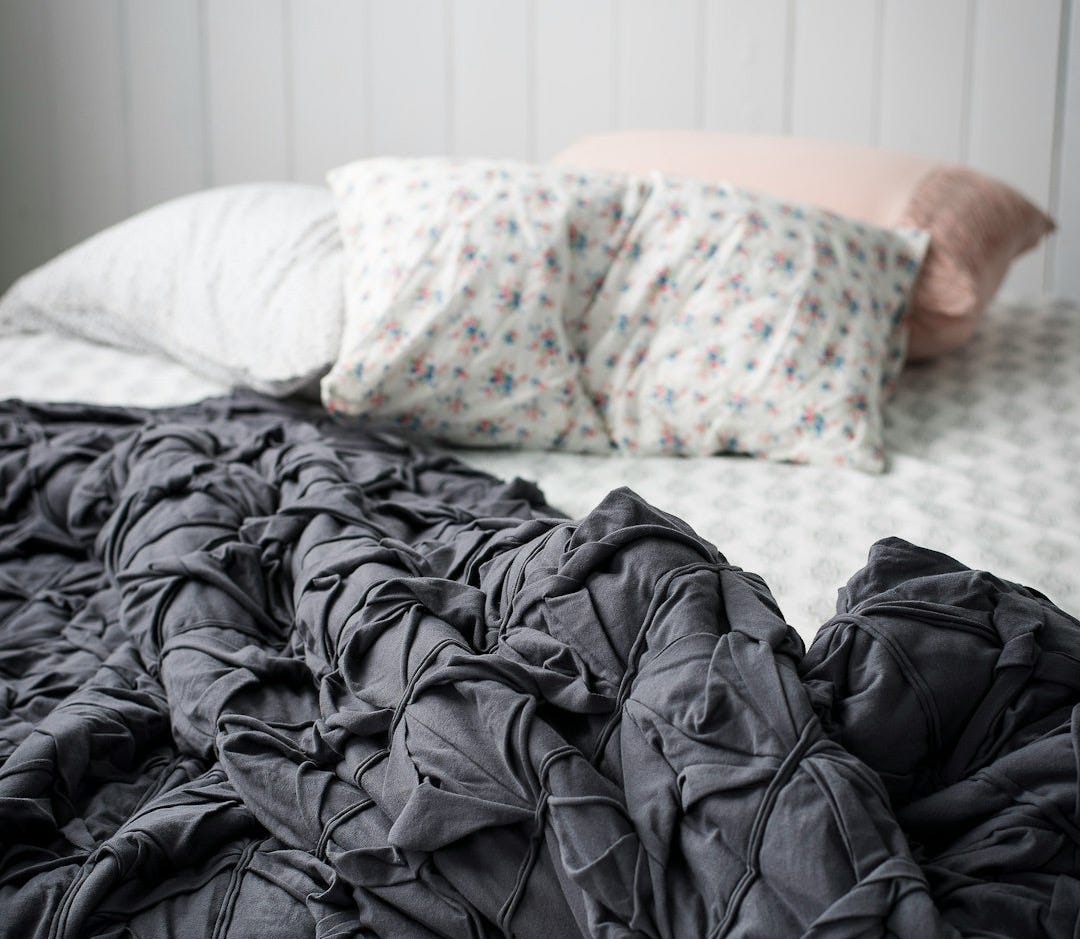 closeup photo of gray comforter on bed closeup photo of gray comforter on bed