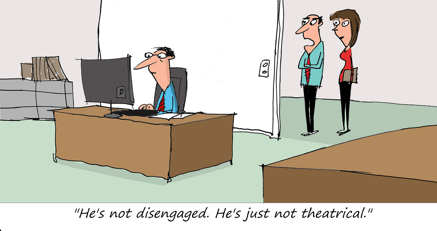 A man works quietly at his desk while two coworkers watch from the doorway. Caption: "He's not disengaged. He's just not theatrical."
