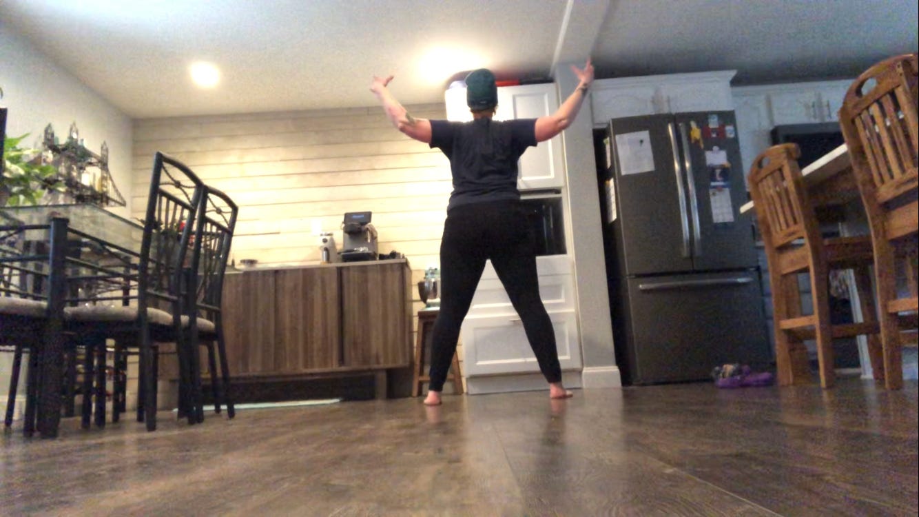 A person dances in a kitchen.