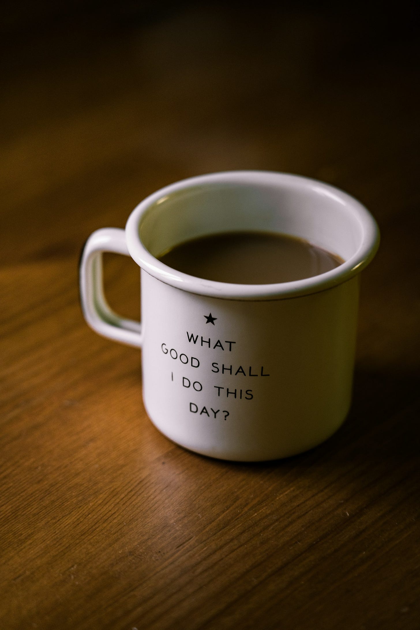 white and black ceramic cup filled with brown liquid on brown wooden sufface white and black ceramic cup filled with brown liquid on brown wooden sufface