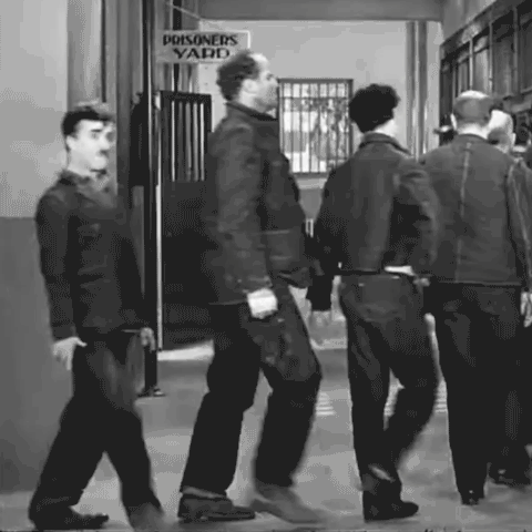 Charlie Chaplin as the tramp walks to his cell in a prison scene from the 1936 film Modern Times. He's disoriented by an accidental dose of drugs and is rotating as he walks