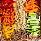 Vibrant & colorful vegetable grazing board with garlic hummus