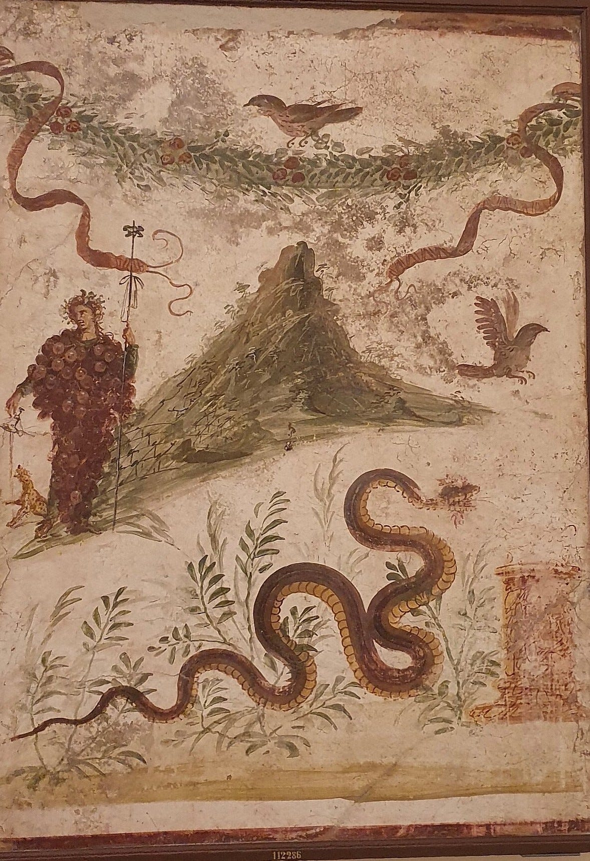 Roman fresco of Bacchus holding a bunch of grapes beside a mountain covered in vines, with a snake below Roman fresco of Bacchus holding a bunch of grapes beside a mountain covered in vines, with a snake below
