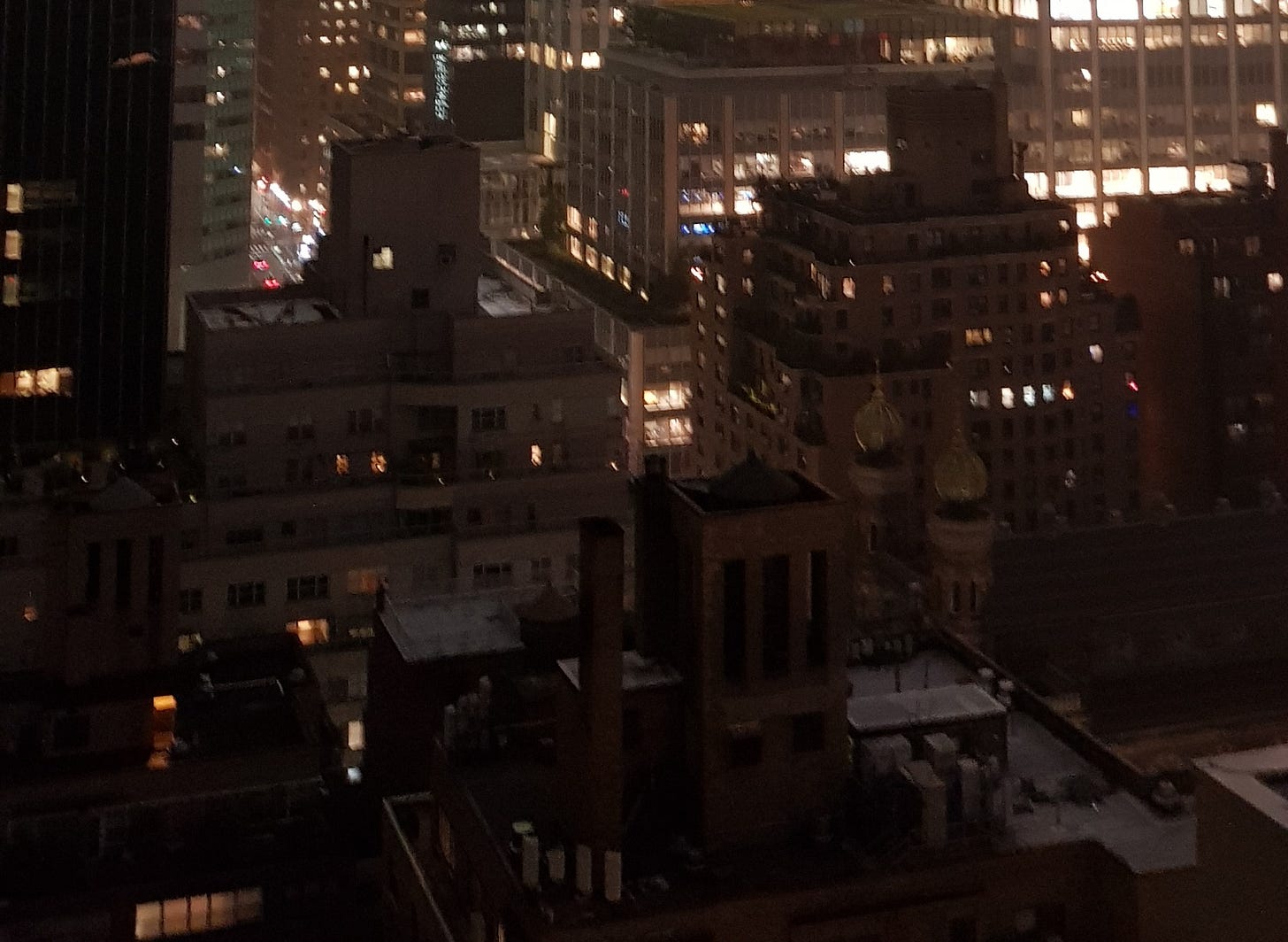 夜裡數棟高樓,頂端沒入低垂的霧氣與燈光中。 夜裡數棟高樓,頂端沒入低垂的霧氣與燈光中。