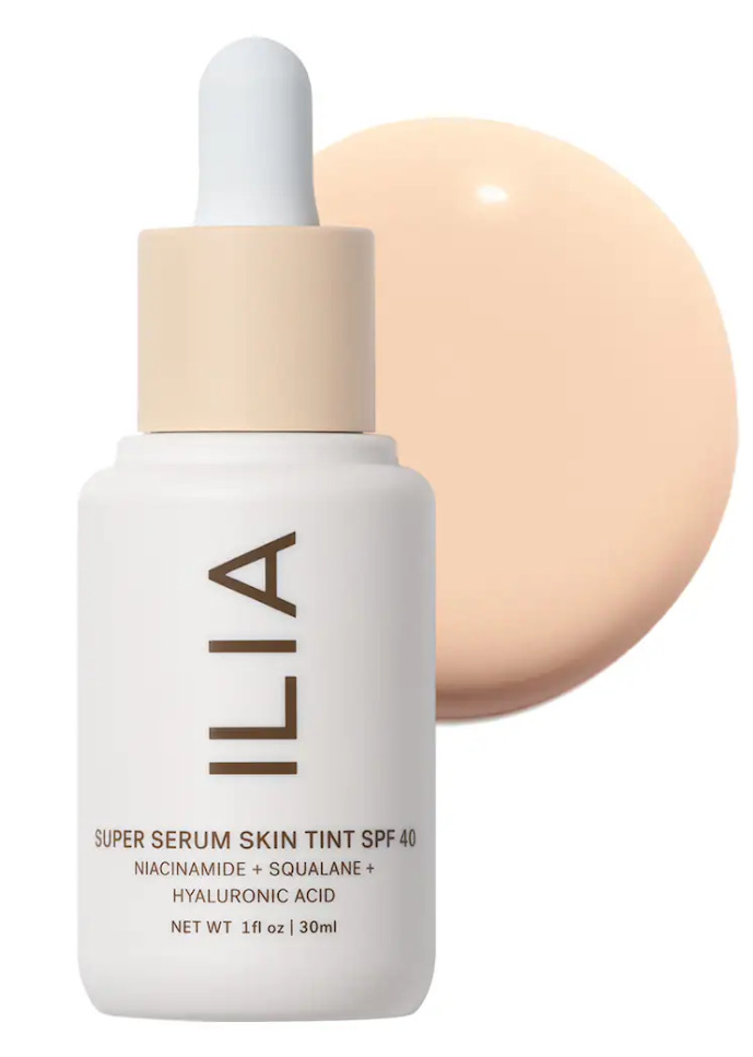 ILIA Super Serum Skin Tint SPF 40 bottle with a dropper and a swatch of the dewy, fluid formula. A cult-favorite American skincare-infused foundation now available at Liberty London.
