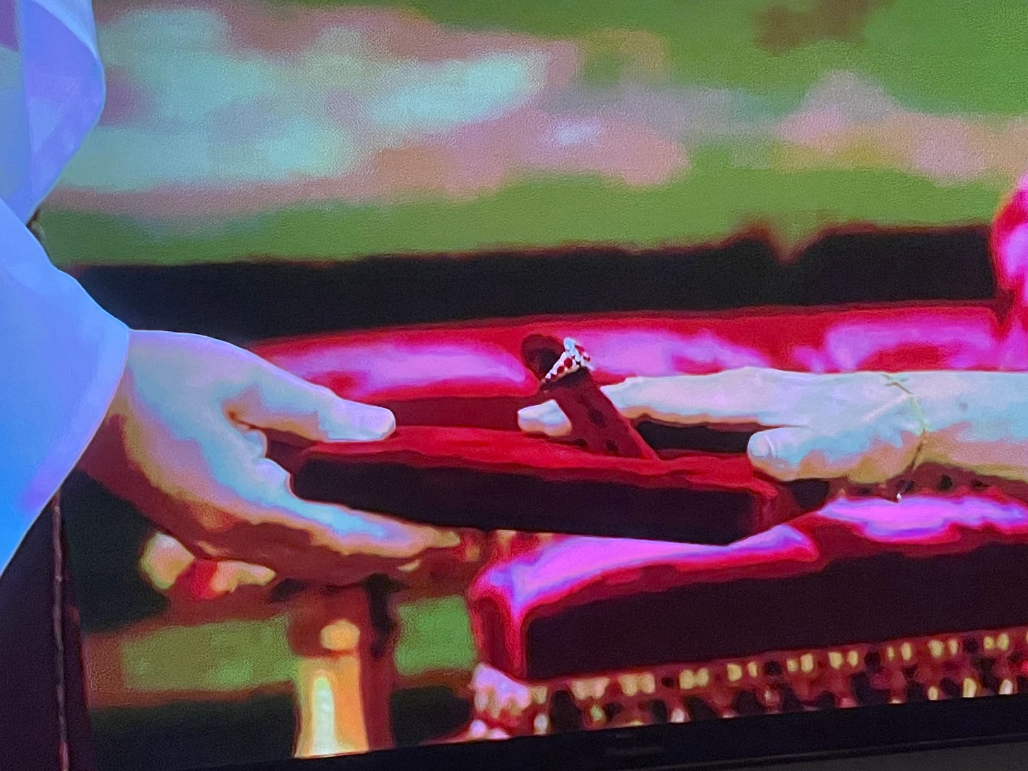 Still shot of a hand reacScreenshot of a hand resting next to a ring on an extremely phallic-shaped ring holder sticking up from a red velvet cushion Still shot of a hand reacScreenshot of a hand resting next to a ring on an extremely phallic-shaped ring holder sticking up from a red velvet cushion