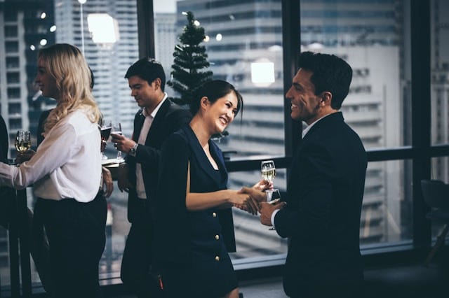People at a networking event holding glasses of wine