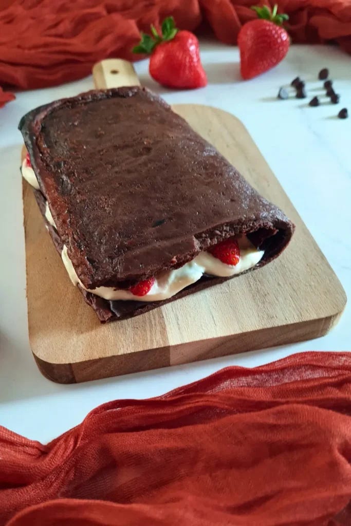 An appetizing chocolate cottage cheese flatbread, featuring rich dark chocolate layers and creamy white cottage cheese, adorned with vibrant red strawberry slices, presented on a wooden cutting board. The composition is enhanced by a scattering of chocolate chips and additional strawberries, set against a backdrop of a ruffled red cloth, creating a visually appealing and indulgent dessert scene. An appetizing chocolate cottage cheese flatbread, featuring rich dark chocolate layers and creamy white cottage cheese, adorned with vibrant red strawberry slices, presented on a wooden cutting board. The composition is enhanced by a scattering of chocolate chips and additional strawberries, set against a backdrop of a ruffled red cloth, creating a visually appealing and indulgent dessert scene.