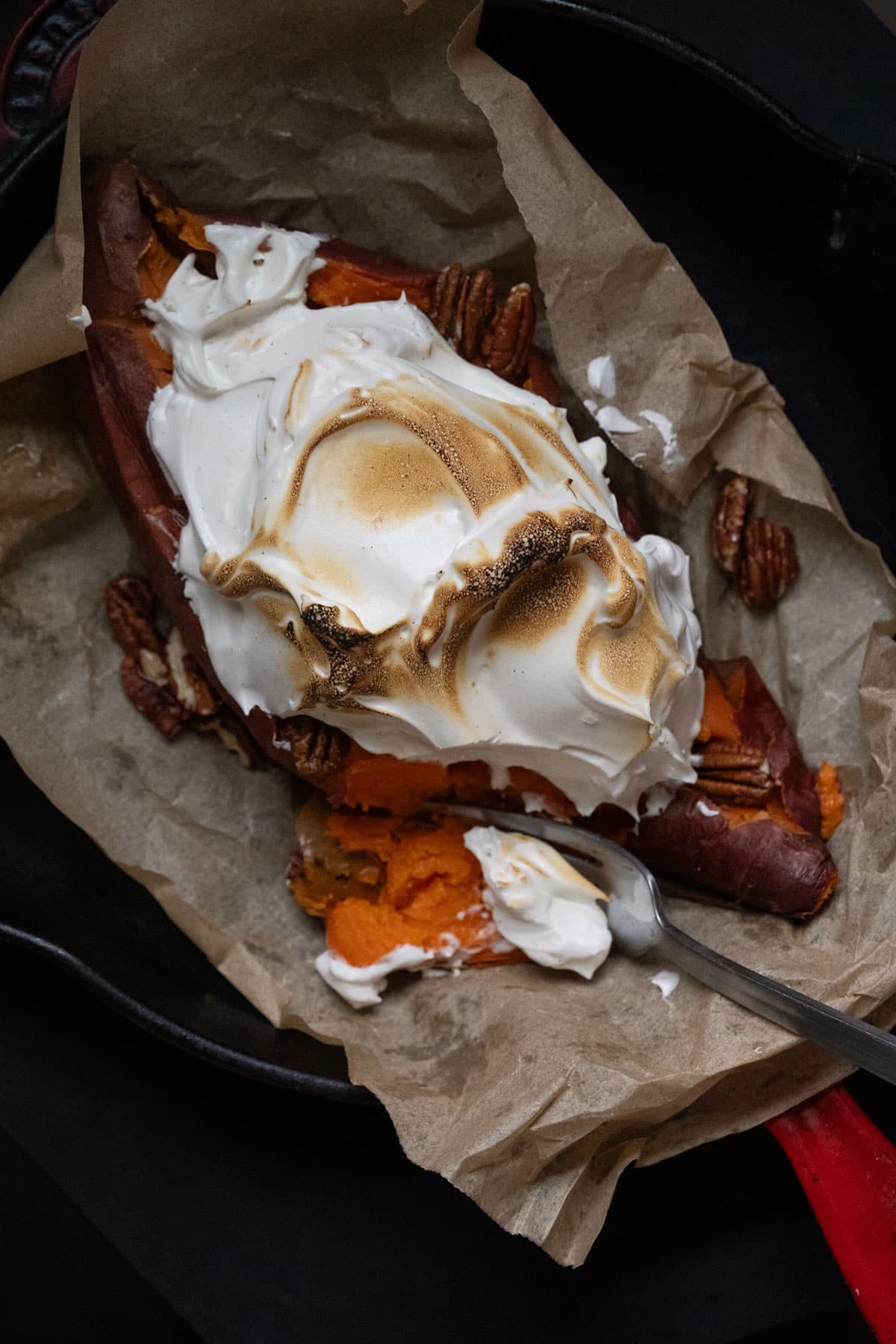 Homemade honey marshmallow fluff topping a baked sweet potato