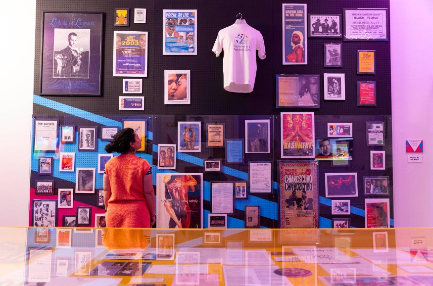 A woman looking at a display of posters and t shirts A woman looking at a display of posters and t shirts