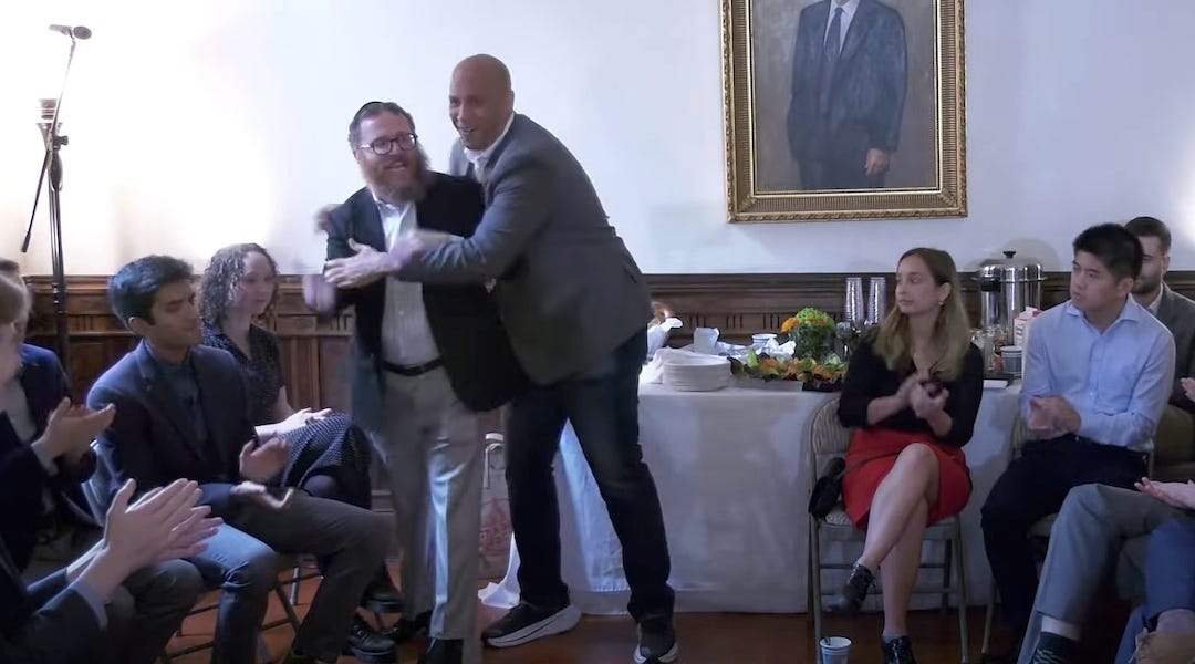 New Jersey Sen. Cory Booker (D) hugs Rabbi Shmully Hecht at an event for Shabtai, a Jewish society at Yale University, Oct. 25, 2022, in New Haven, Connecticut. Booker co-founded the organization with Hecht. (Screenshot via YouTube)