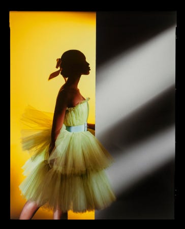 Naomi Campbell pose en robe de soirée d'un vert tirant sur le jaune et donc la forme rappelle un tutu de danse