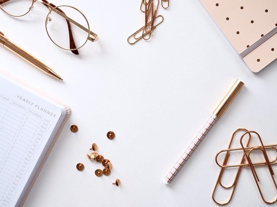 gold toned office supplies on white surface