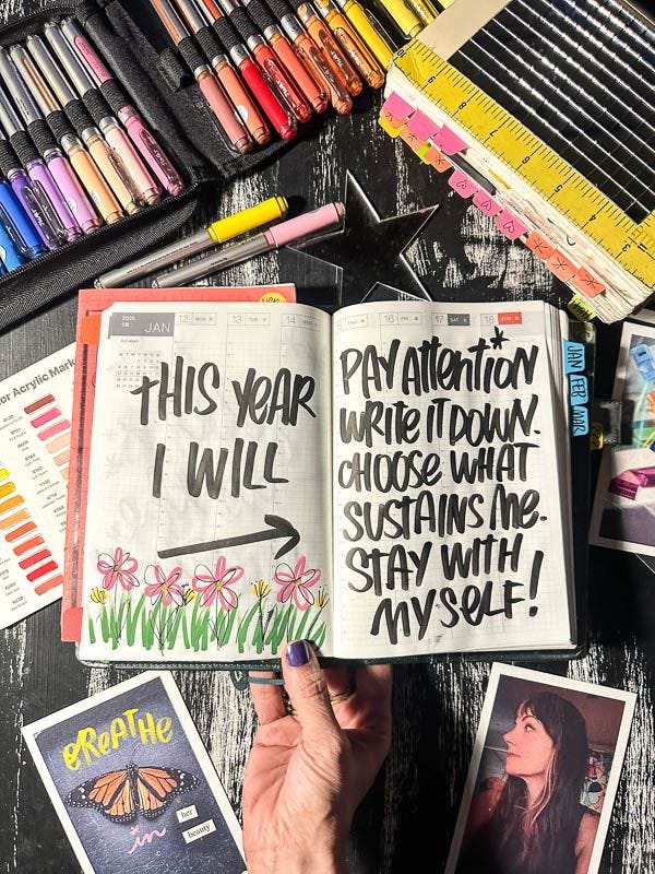 This may contain: a person holding an open book with writing on it next to some crayons and pencils