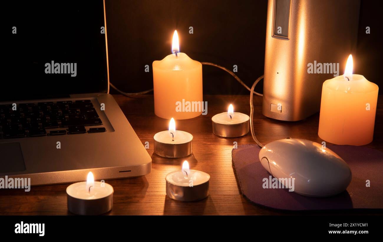 Blackout concept, 6 lit candles illuminating the workspace with a ...