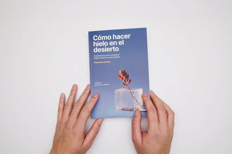 Dos manos sujetan el libro Cómo hacer hielo en el desierto