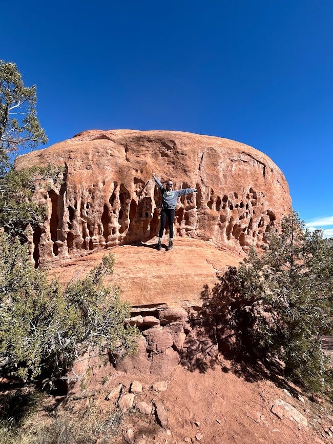 girl standing on a red rock mountain.