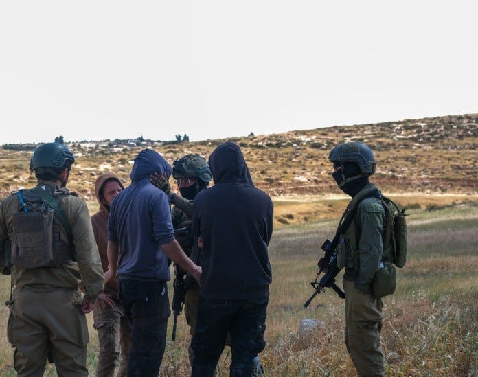 En israelsk kommanderende soldat snakker med en bosetter i Wadi Al-Rakhim, på Vestbredden, 25 april 2025. (Georgia Gee) En israelsk kommanderende soldat snakker med en bosetter i Wadi Al-Rakhim, på Vestbredden, 25 april 2025. (Georgia Gee)