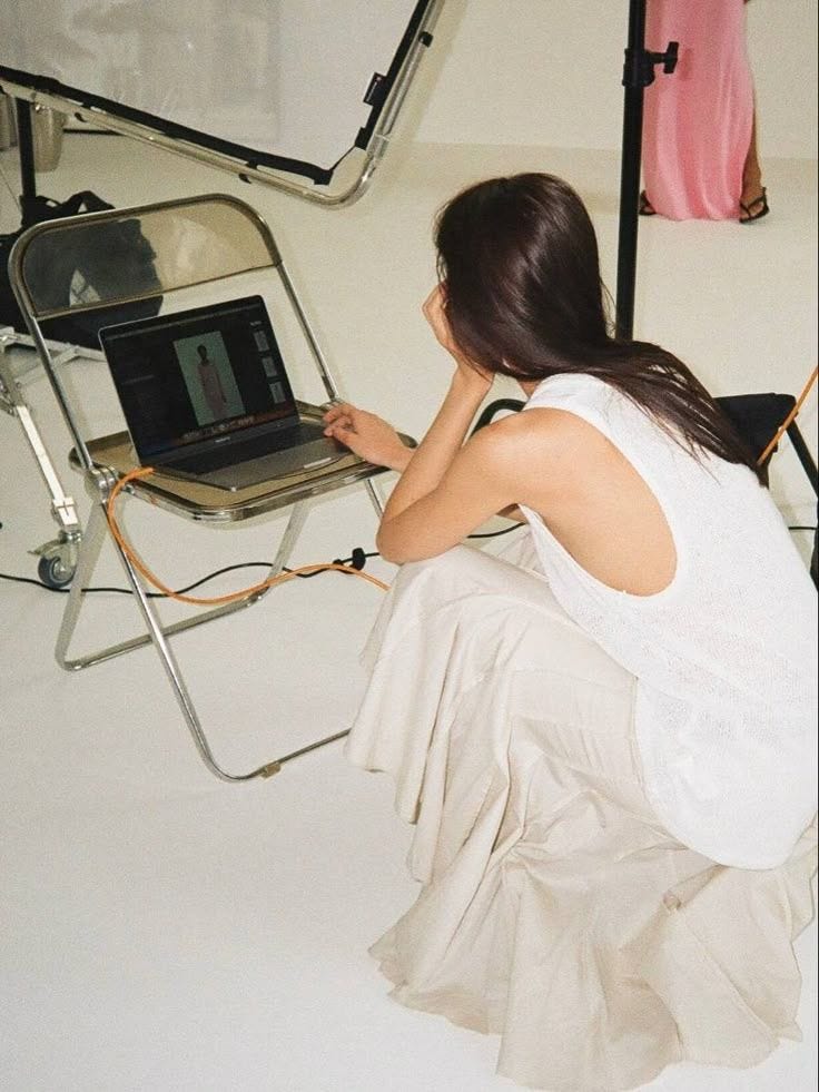 This may contain: a woman sitting in front of a laptop computer This may contain: a woman sitting in front of a laptop computer