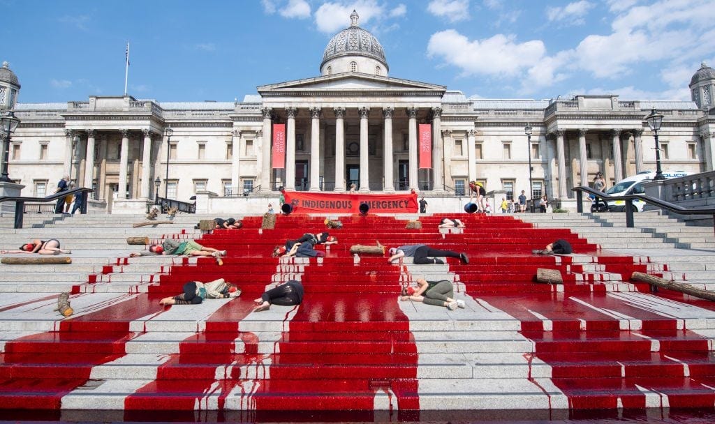Extinction Rebellion pour dye down the steps near the National Gallery in Trafalgar Square, London, during a protest in solidarity with indigenous communities in Brazil who are dying from Covid-19. Photo by Dominic Lipinski/PA Images via Getty Images. Extinction Rebellion pour dye down the steps near the National Gallery in Trafalgar Square, London, during a protest in solidarity with indigenous communities in Brazil who are dying from Covid-19. Photo by Dominic Lipinski/PA Images via Getty Images.