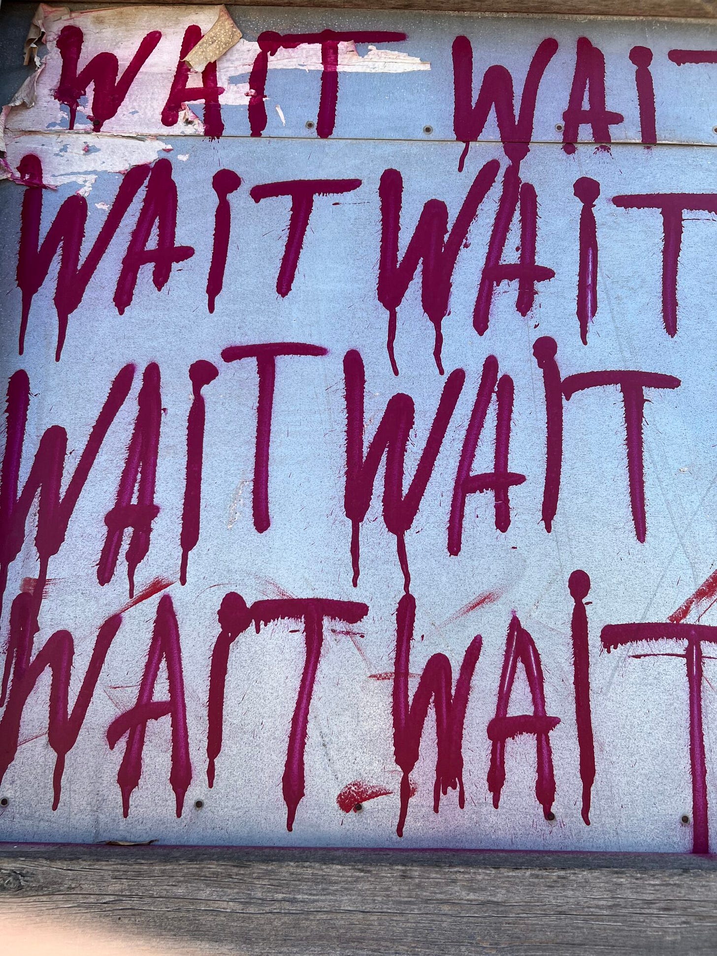Street art in Tel Aviv, „Wait“ in roter Schrift auf weißer Wand Street art in Tel Aviv, „Wait“ in roter Schrift auf weißer Wand
