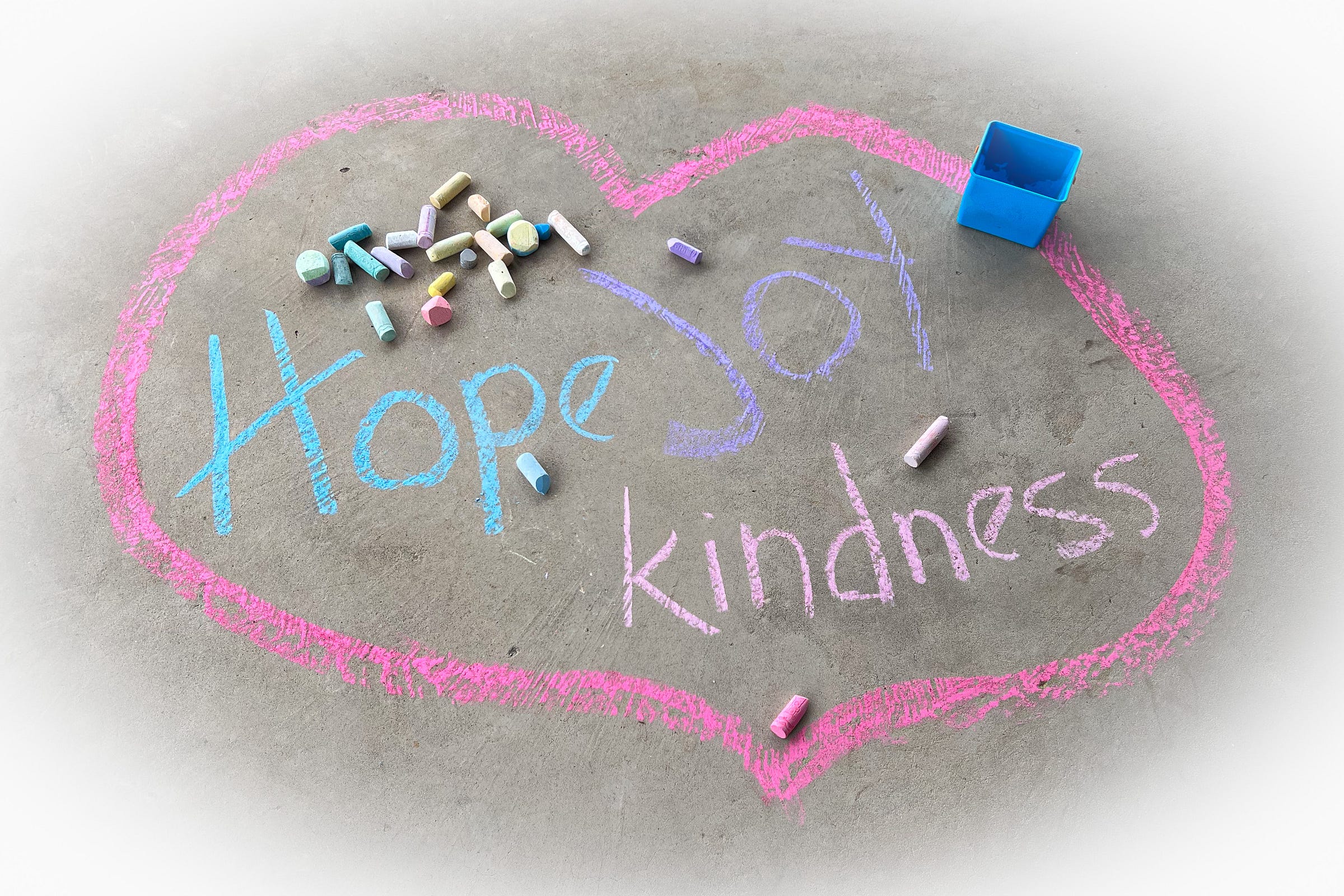 Chalk art with the words hope, joy, and kindness encircled by a pink heart