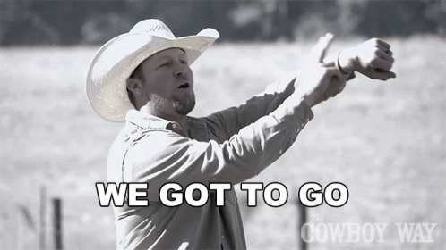 a man in a cowboy hat is standing in front of a sign that says we got to go