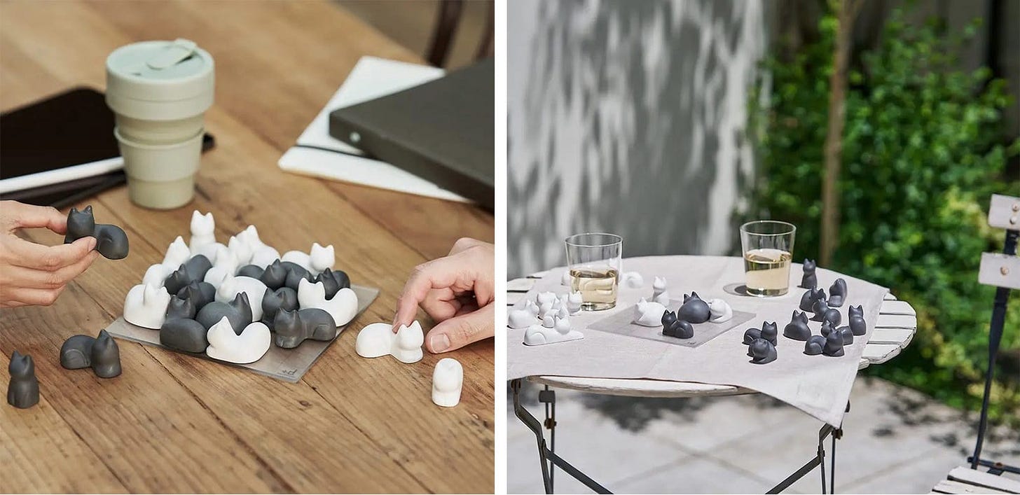 Two images side-by-side showing an arrangement of black-and-white pieces shaped like cats that can be fit onto a grid. The left-hand image shows two hands playing pieces next to a coffee cup on a table. The image on the right shows an outdoor table with the game on a table with two drinks glasses.