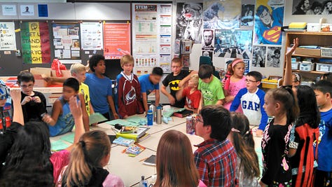 Students working on various projects throughout a classroom. 