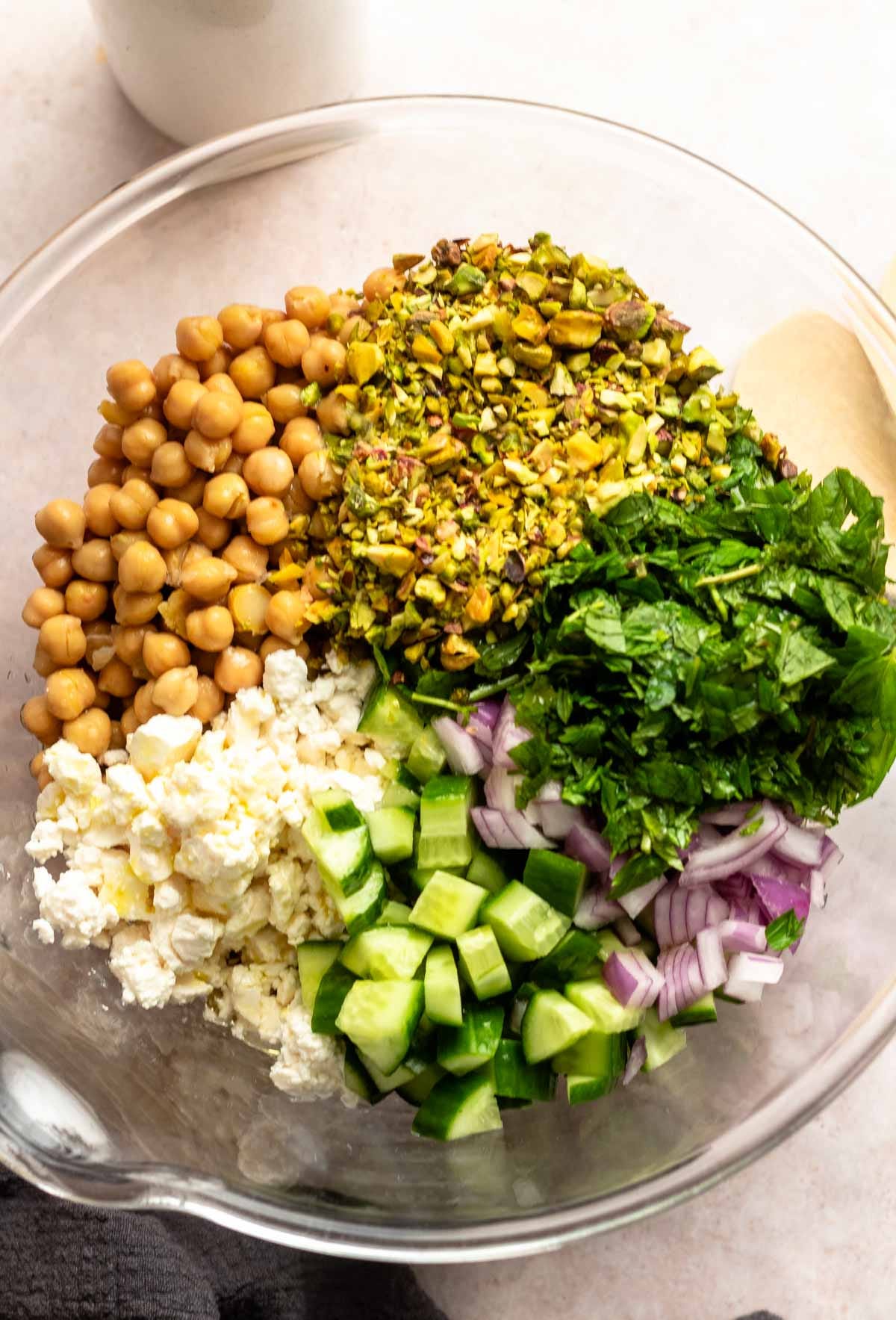 Top of a large glass bowl with unmixed salad. Top of a large glass bowl with unmixed salad.