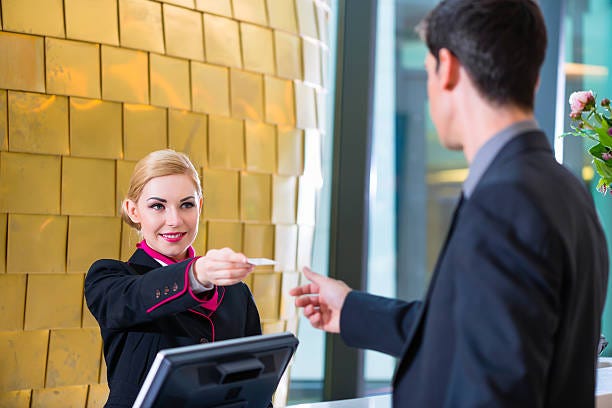 Hotel receptionist check in man giving key card