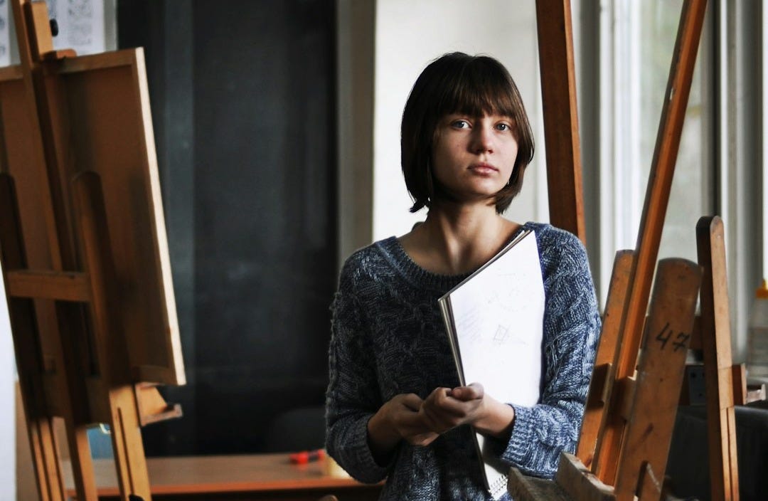woman holding art book inside art studio woman holding art book inside art studio