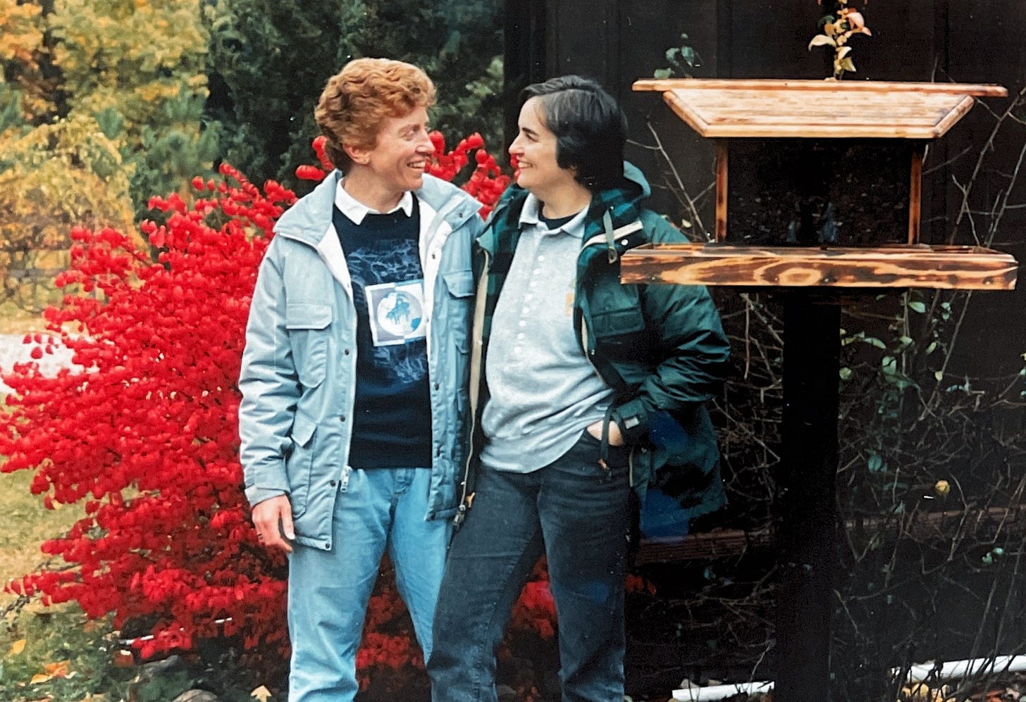 Two women surrounded by fall colors looking lovingly into each others eyes