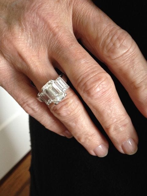 This may contain: a man's hand with an engagement ring on it