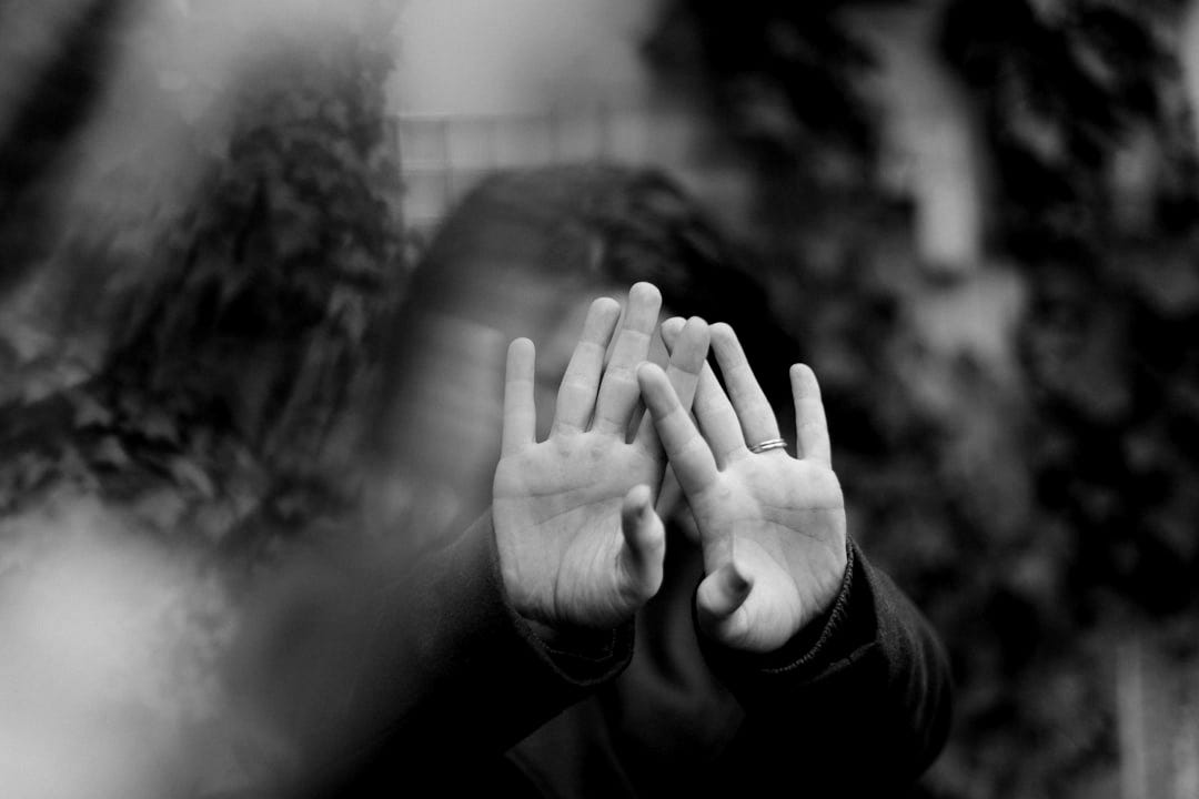 person in brown long sleeve shirt covering face with hand
