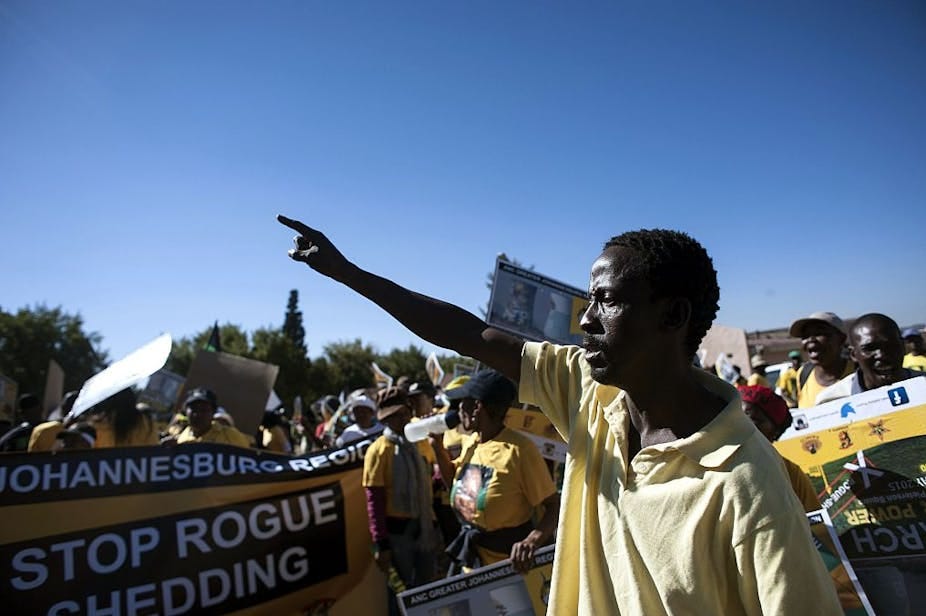 People outdoors, holding banners and gesticulating