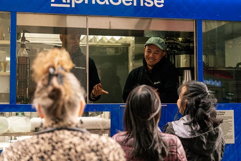 Visual: NYC activation — branded coffee cart near Wall Street, product specialists in conversation.