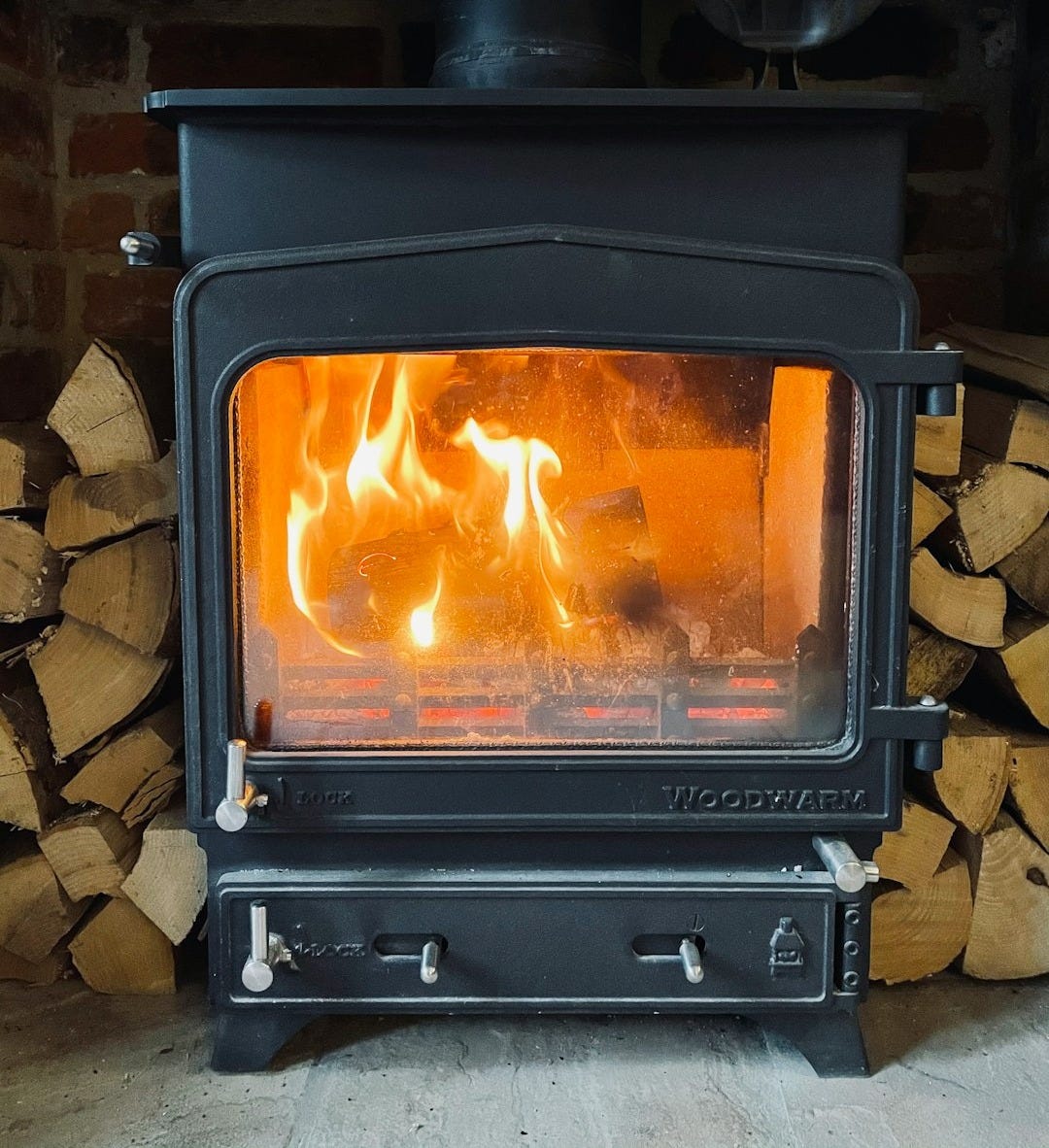 black wood burner near brown brick wall