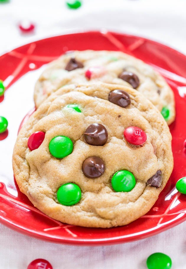 two M&M's Christmas cookies on a red plate. two M&M's Christmas cookies on a red plate.