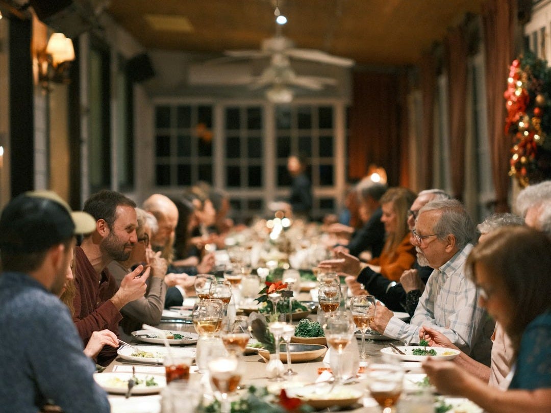 a group of people sitting at a long table