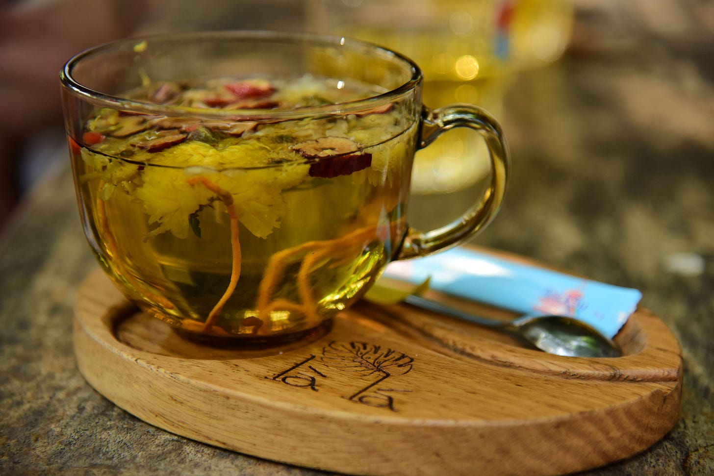 A cup of rich black tea featuring cocoa notes, loose leaves, and mixed herbs on a rustic surface. A cup of rich black tea featuring cocoa notes, loose leaves, and mixed herbs on a rustic surface.