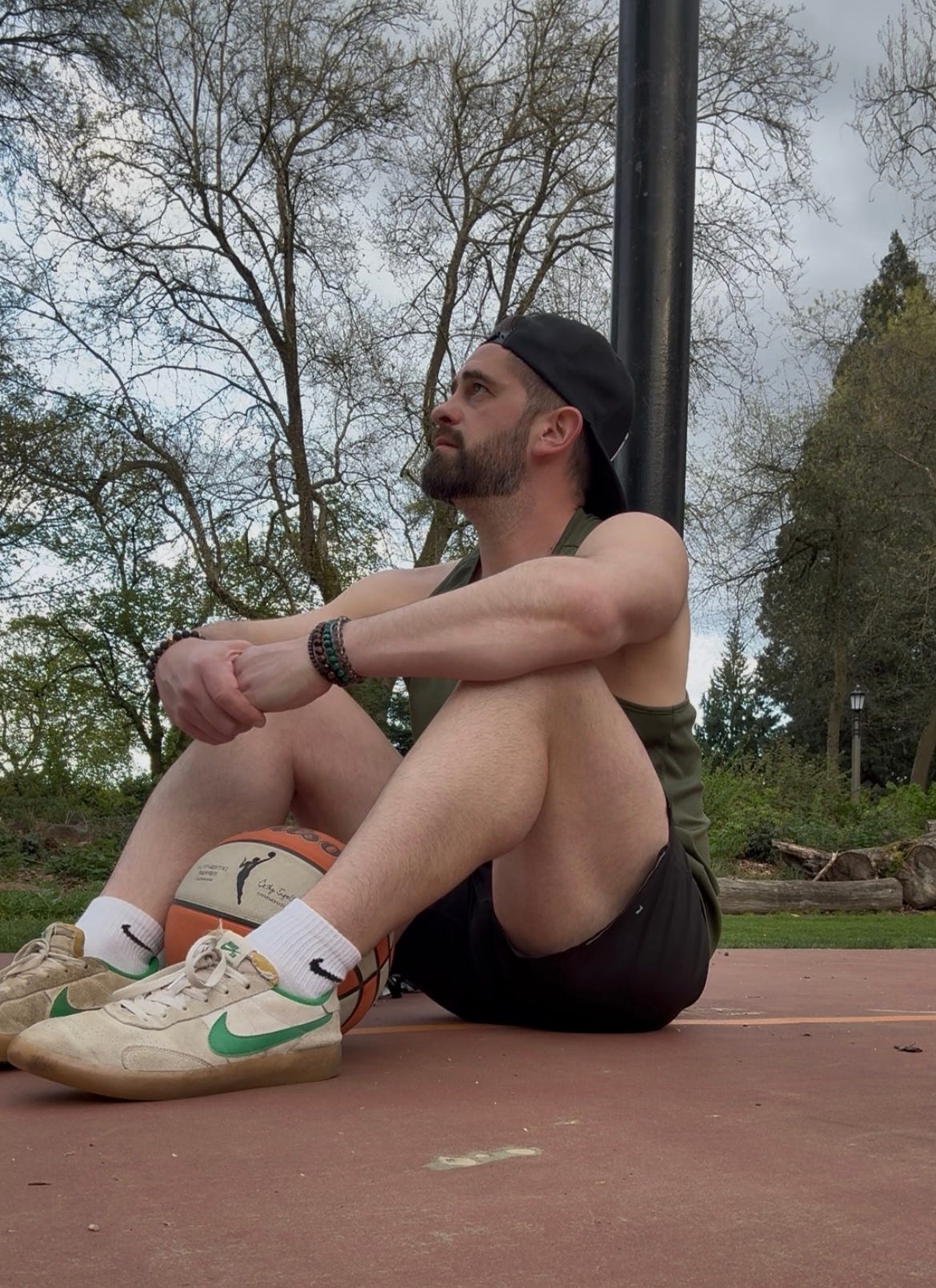 Man sitting talking about money on basketball court