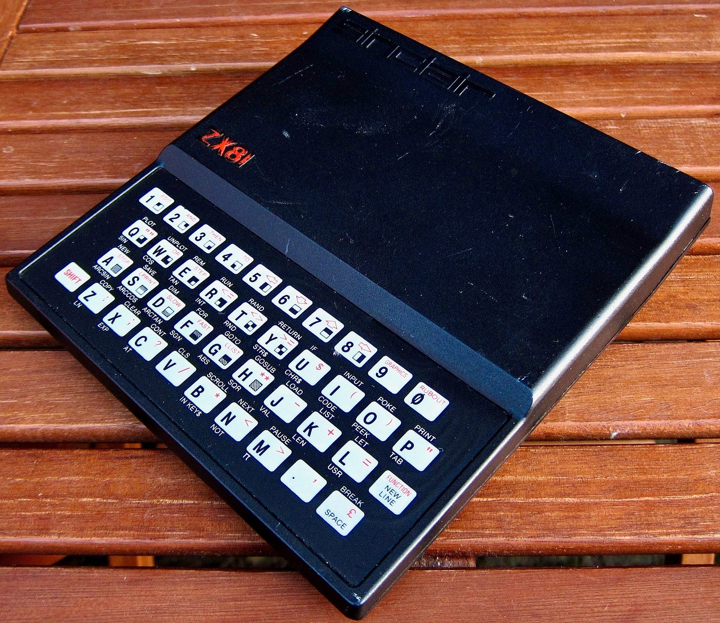 A well-used Sinclair ZX81 computer on a wooden table. 