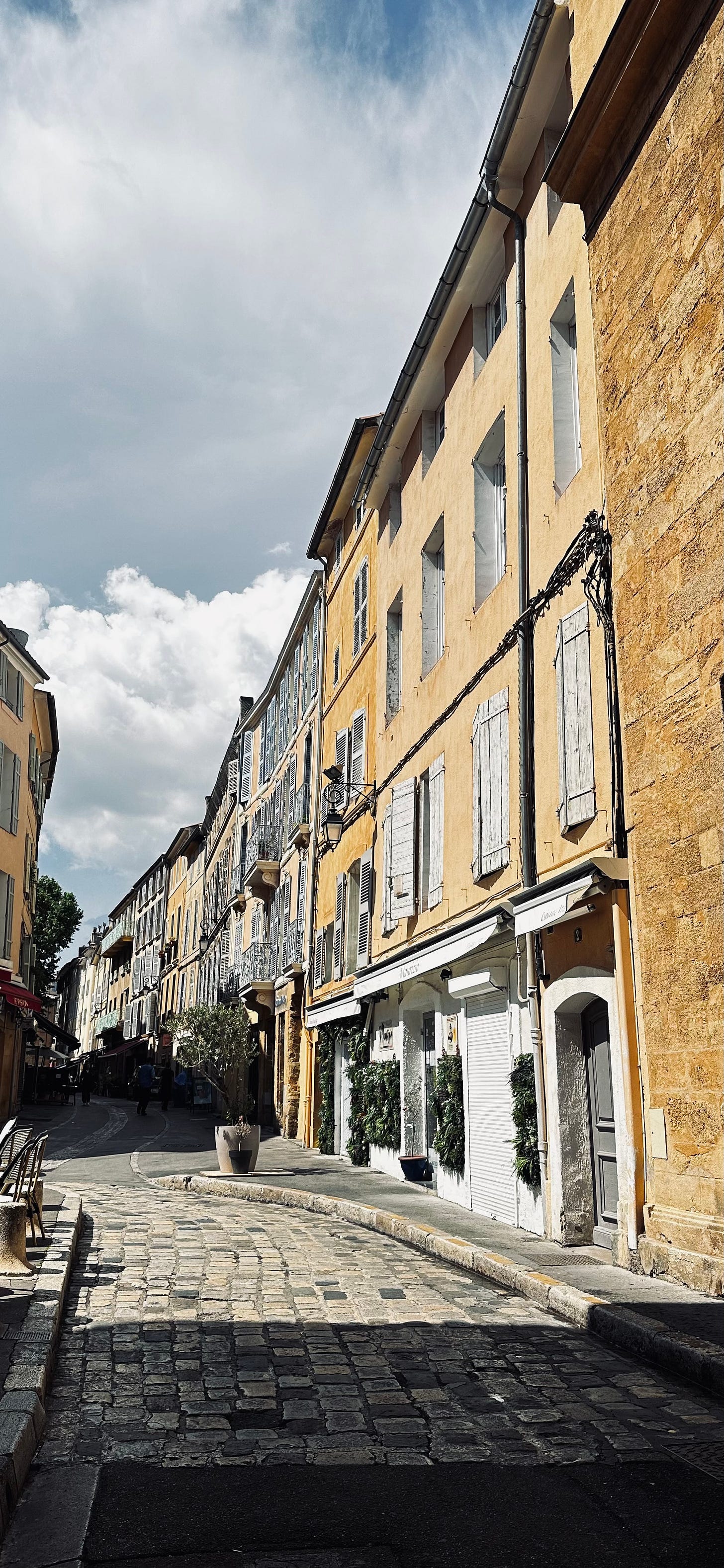 Quiet European street with warm stone buildings and soft light, photographed at street level during a slow travel stay.