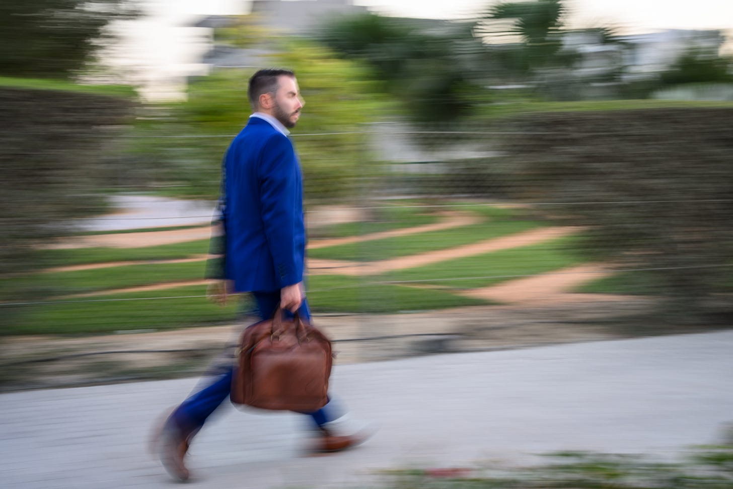 Man in a business suit walking quickly with a blurred background Man in a business suit walking quickly with a blurred background