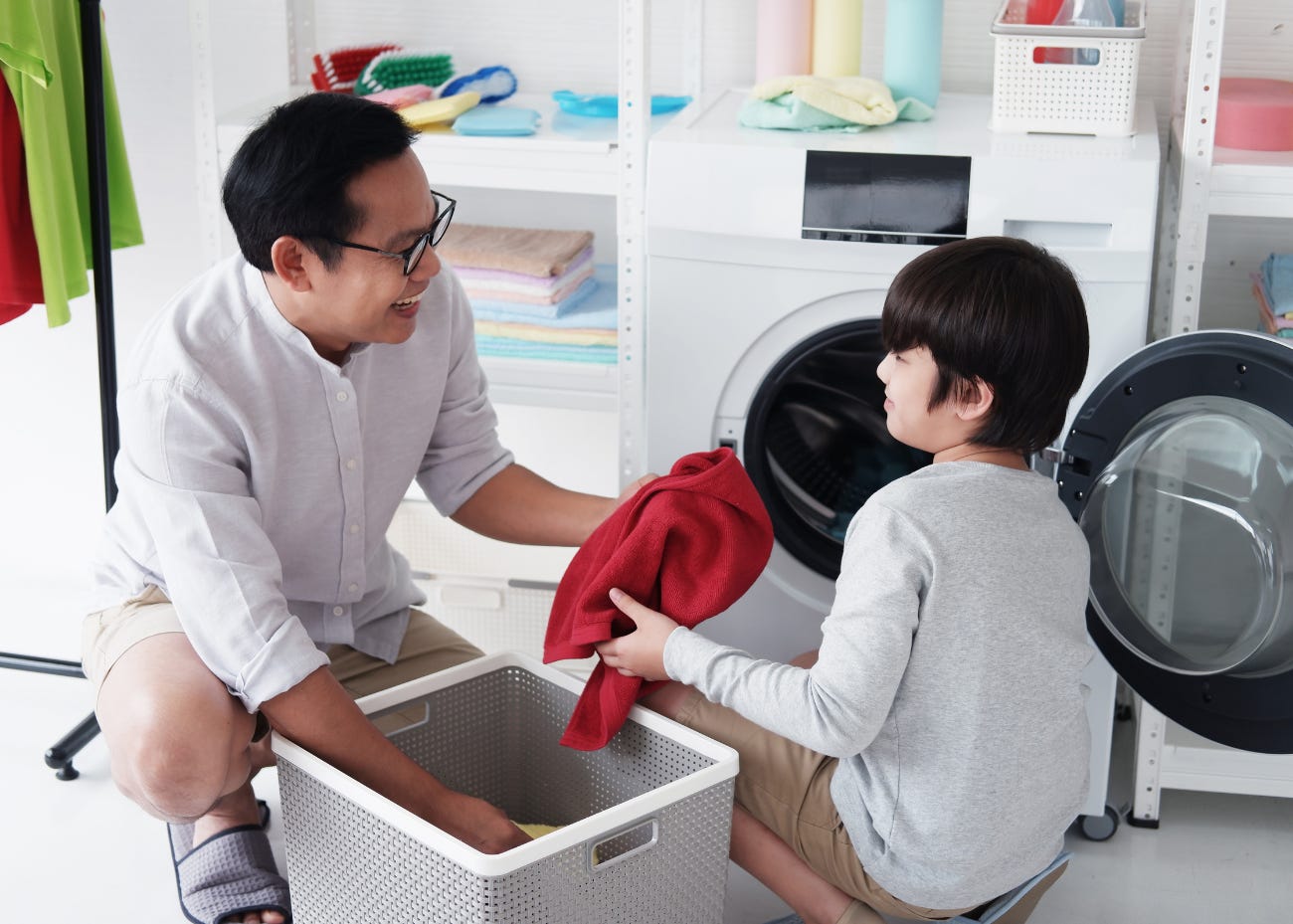 parent and child doing laundry together