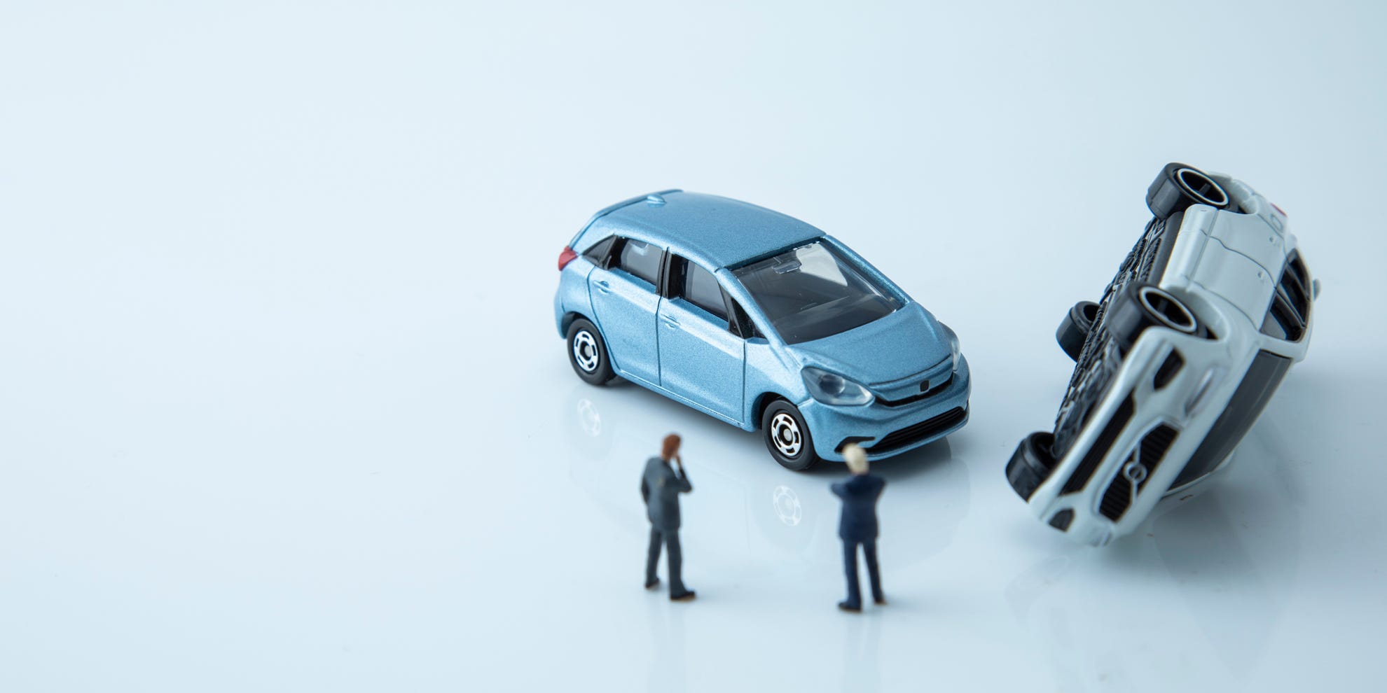 Two toy men looking at two toy cars that have crashed representing writing rules. Two toy men looking at two toy cars that have crashed representing writing rules.