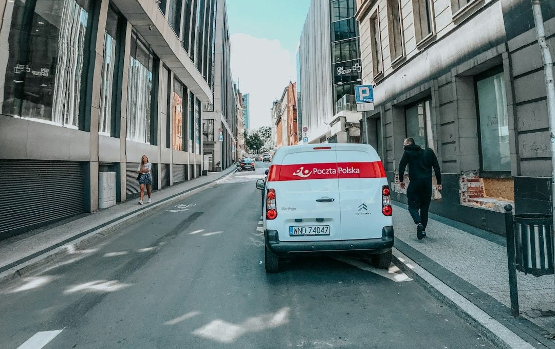 white van on road near building during daytime white van on road near building during daytime