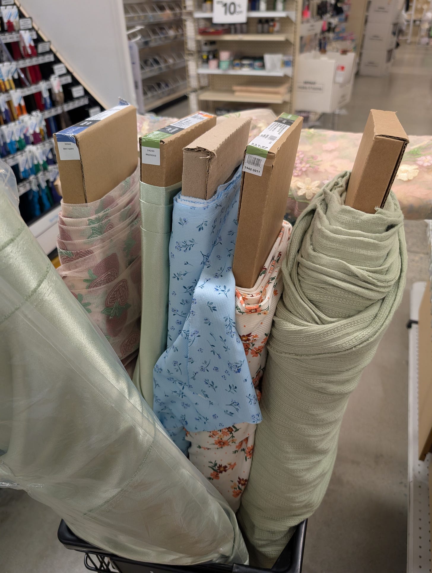 a cart full of bolts of fabric in the zipper aisle