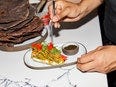 A person holds at plate of food at Mitica. 